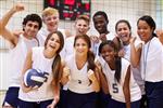 Happy co-ed volleyball team grouped with coach for a picture